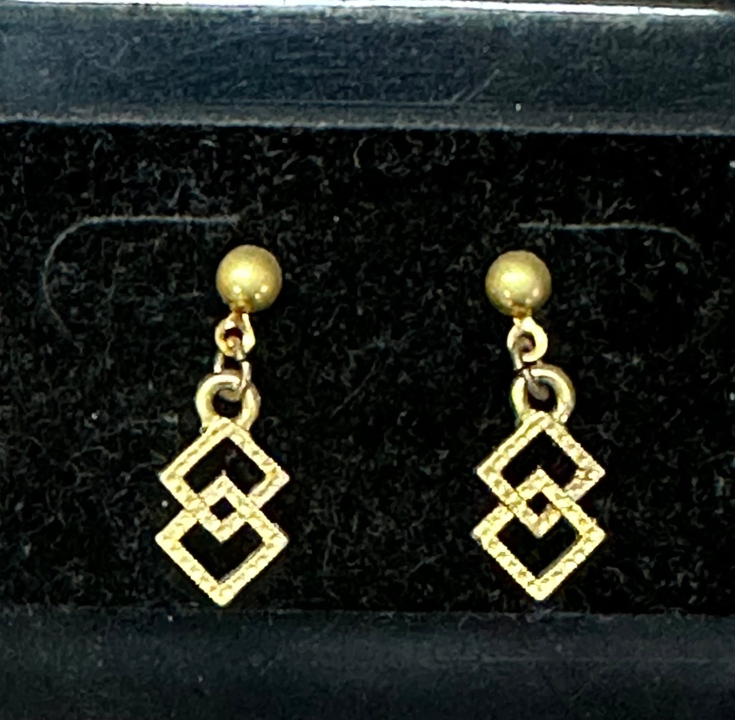 Showcased against a black backdrop, the Square Up Fashions' Dangling Square and Round/Double Squares Dance Earrings are unique jewelry pieces that capture elegance and movement with their geometric design.