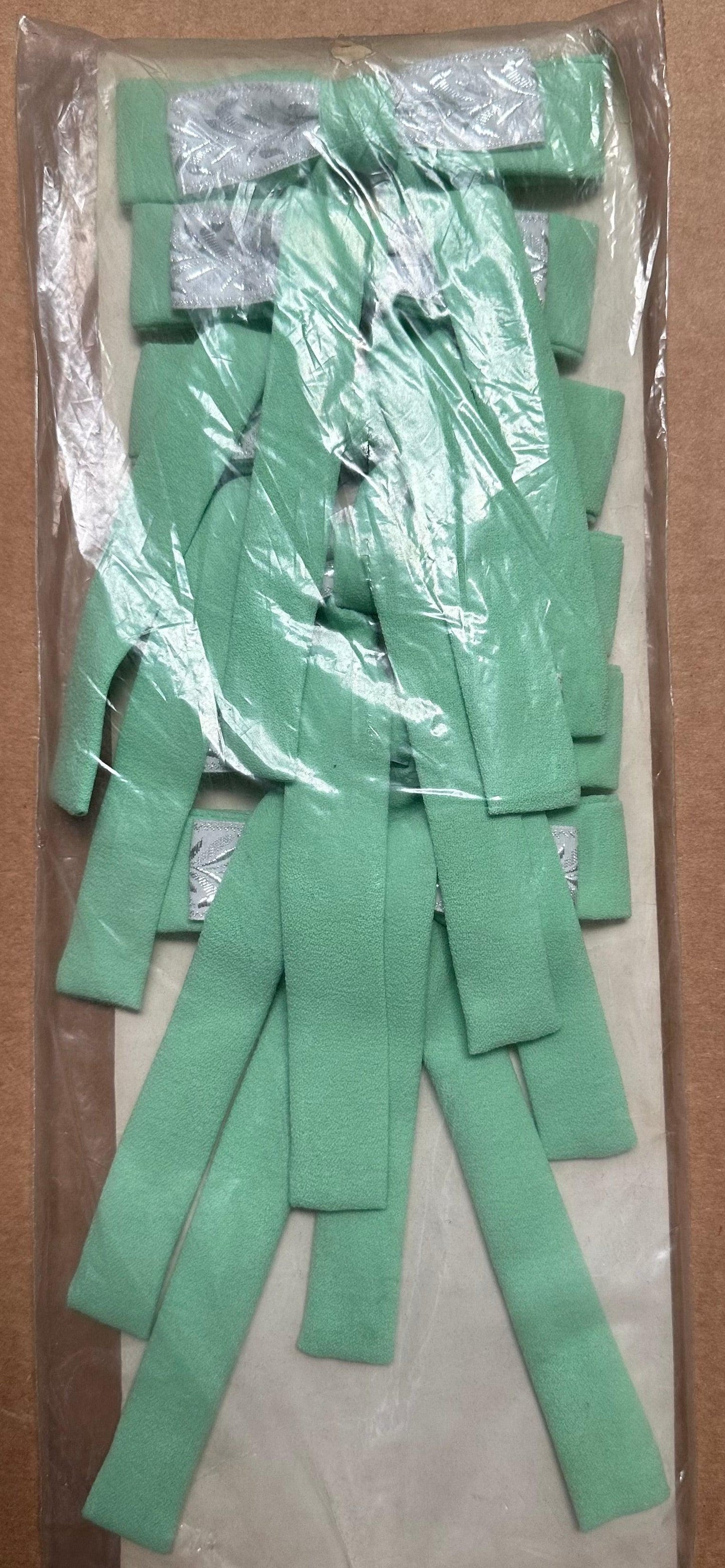 A packaged set called Colonel Ties, from the brand Square Up Fashions, featuring green elastic bands that capture the charm of a southern bow tie. They are arranged vertically in rows and secured with gray clips inside a clear plastic wrapper.