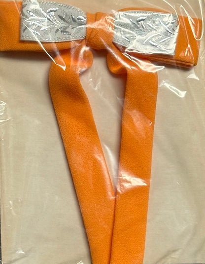 A necktie from Square Up Fashions' Colonel Ties collection, featuring an orange design accented with a silver and white decorative section at the top, reminiscent of a classic Southern bow tie, neatly displayed inside clear packaging.