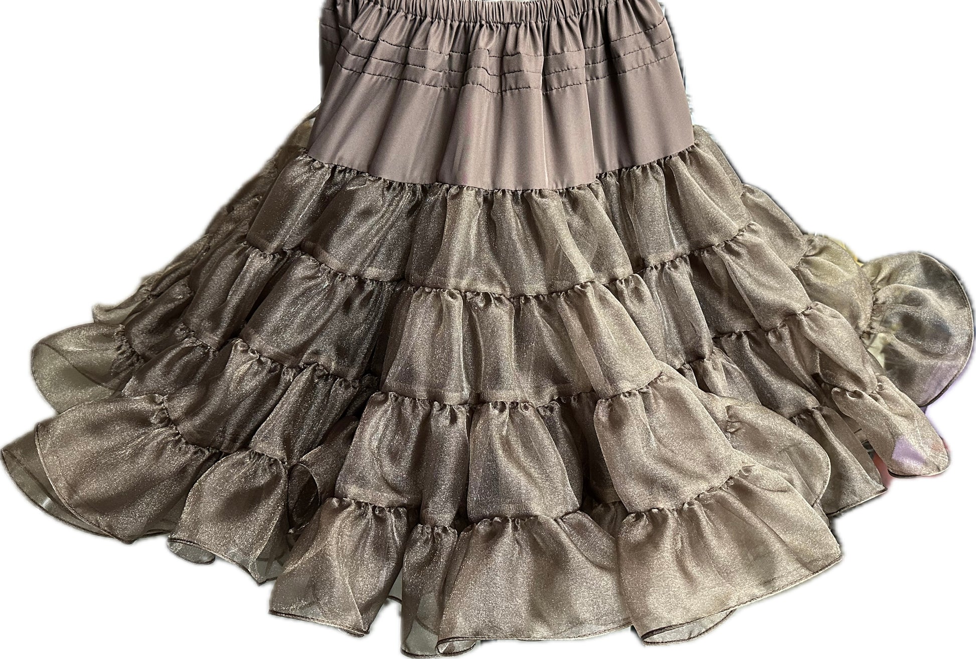 The Crystal Petticoat from Square Up Fashions is a multi-tiered ruffled skirt featuring an elastic waistband, crafted from sheer metallic crystal fabric in a champagne hue.