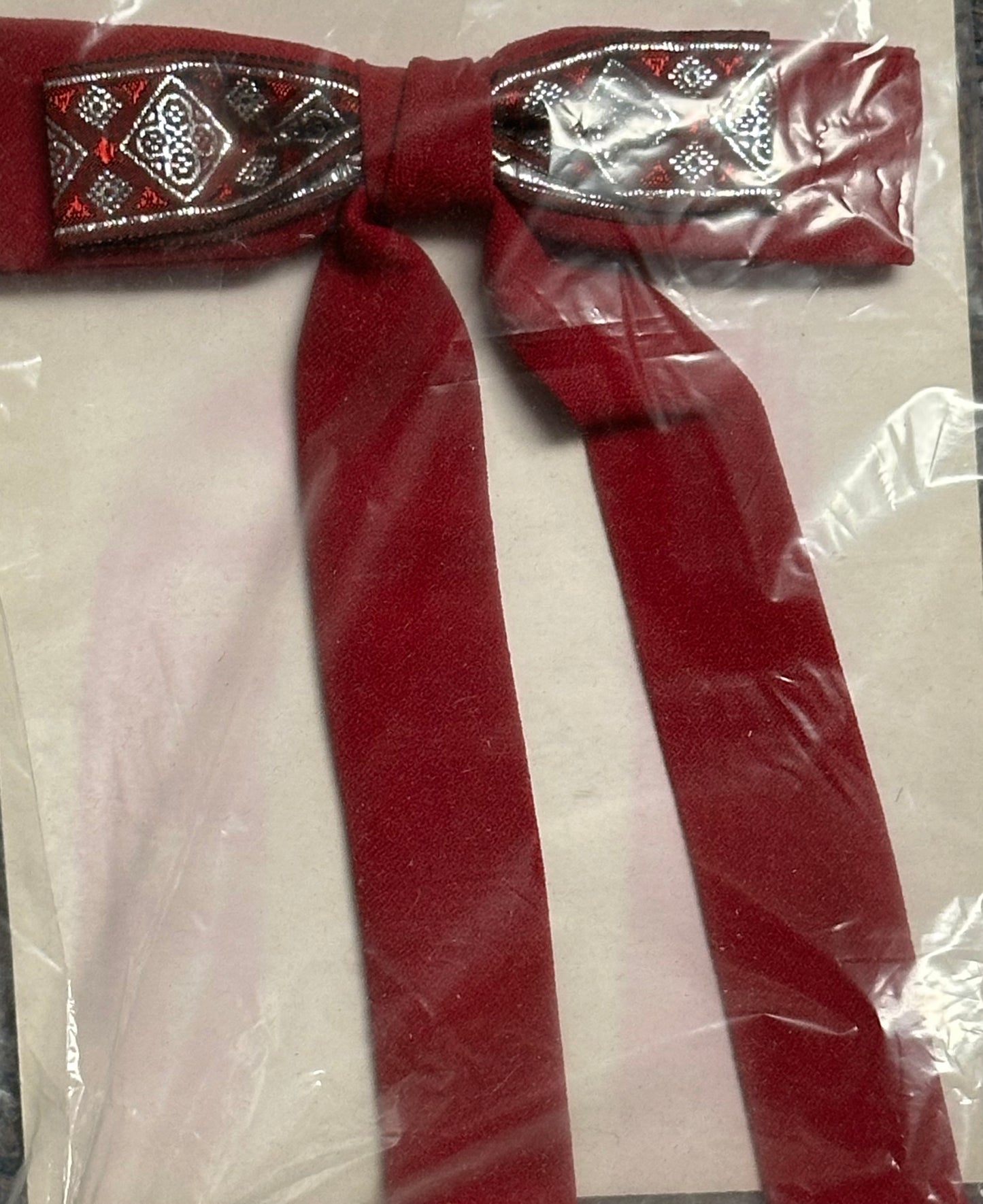 The Colonel Ties from Square Up Fashions, featuring a red decorative bow with patterned knot detail in clear plastic packaging, are perfect for adding a touch of elegance to your western look.