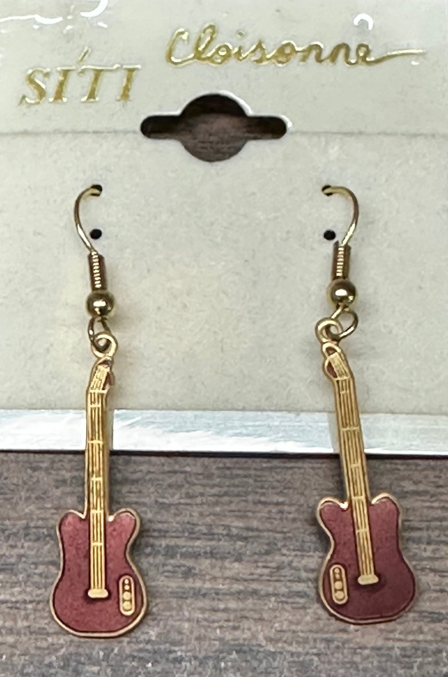 Discover the delightful Guitar Dangle Earrings, presented on a display card under the brand "Square Up Fashions." These music-themed accessories beautifully encapsulate the spirit of Western jewelry with their distinctive design, making them an ideal addition to any earring collection.